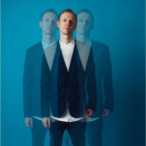 Official Kormac artist-uploaded studio portrait with the complete head visible and two stylized shadow duplicates; archival photo of a billed performer at KORMAC — LIVE AV SHOW, not this event